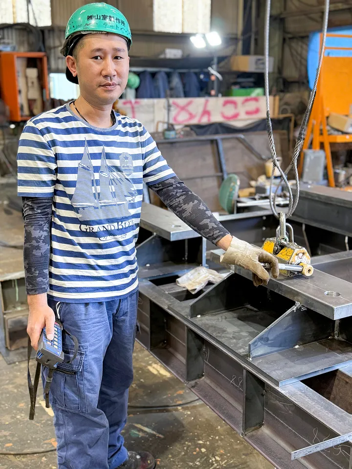 工場内で構造物の吊り上げ準備をする作業員の様子