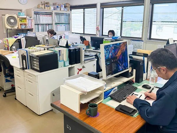 事務所内でパソコン作業をするスタッフたち