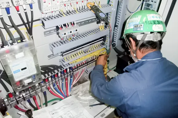 電気制御パネルに細かく配線を施す様子