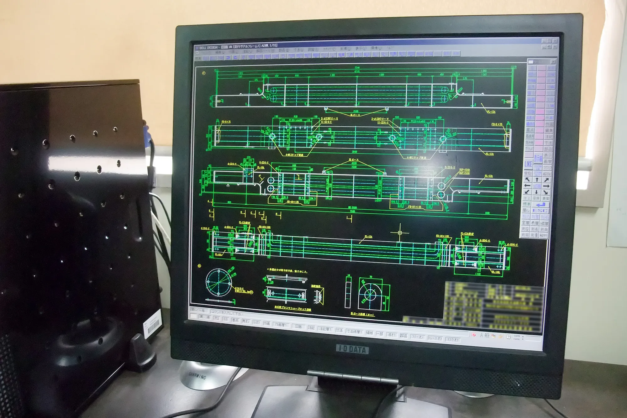 黒い背景に緑と黄色の線で描かれた機械設計図面
