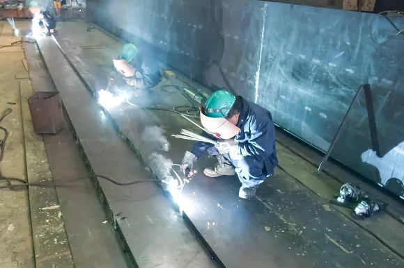 火花を散らして溶接作業を行うスタッフ